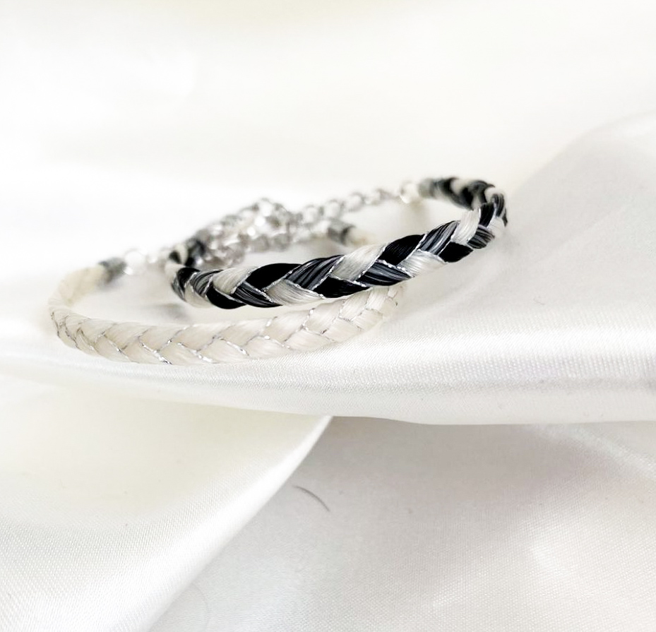 Bracelets doubles tressés en crins, posés sur un tissu clair